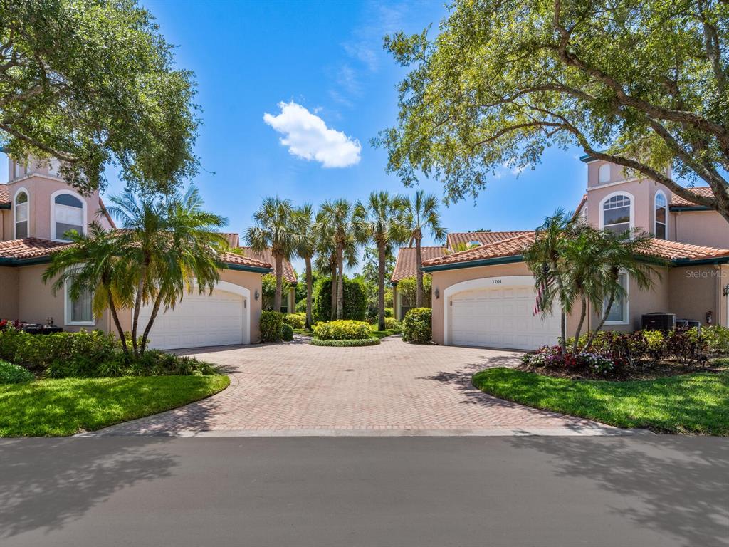 a front view of a house with a garden and palm trees