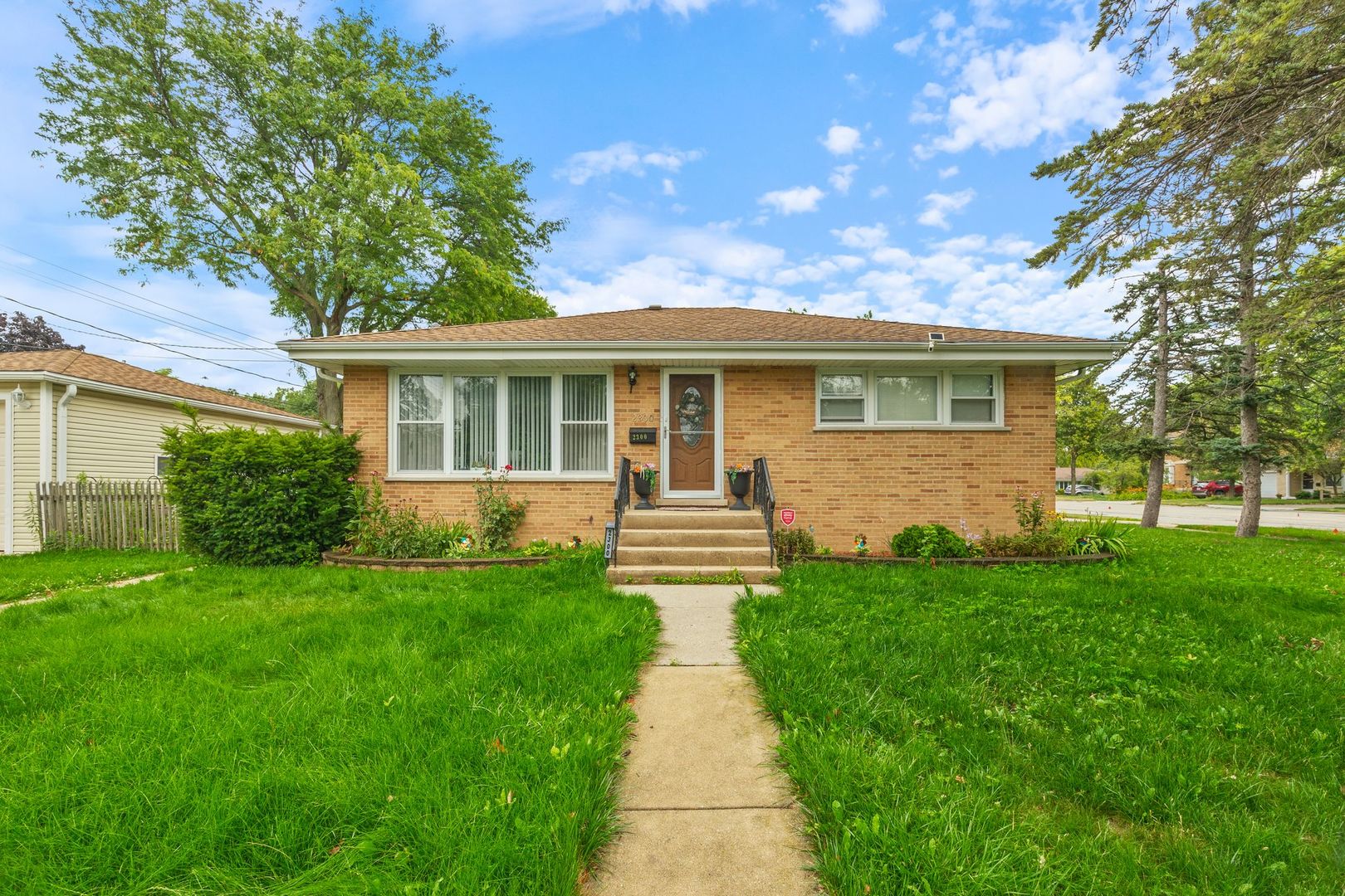 a front view of house with yard and green space