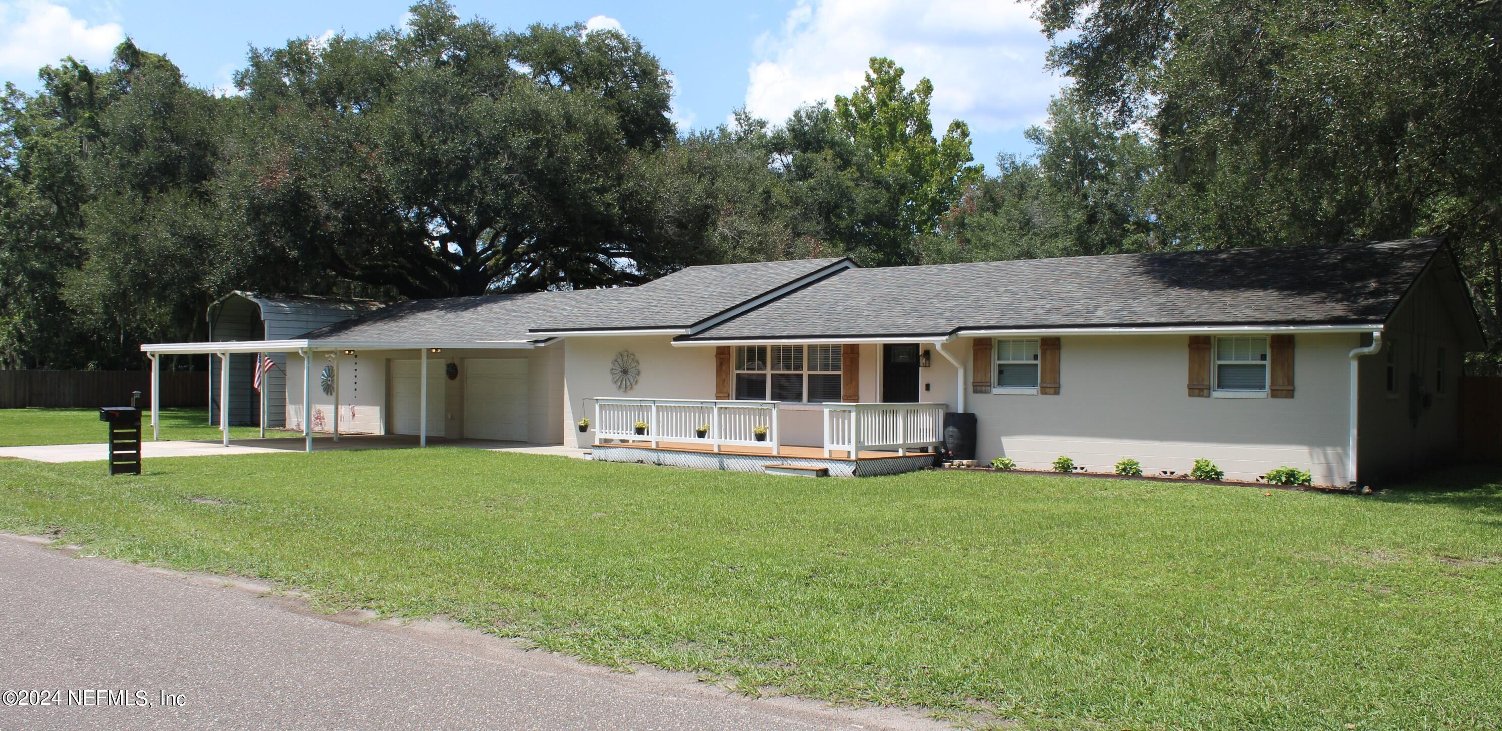 a front view of a house with a garden and trees