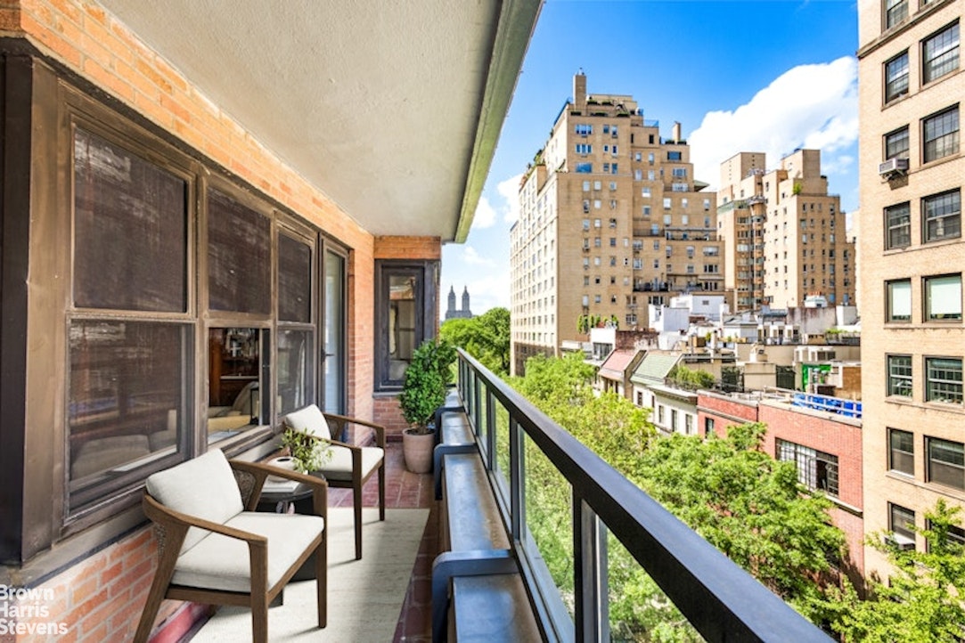 a balcony view with couple of chairs and wooden floor