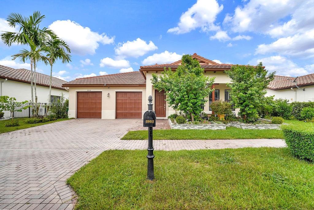 a view of a house with a yard and palm tree