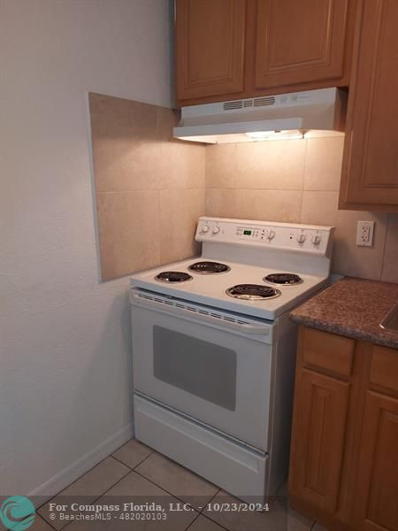 a stove top oven sitting inside of a kitchen