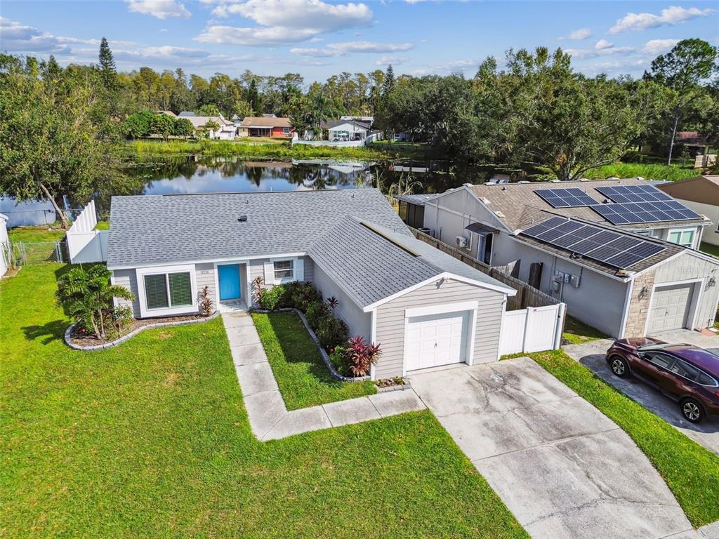 aerial view of a house with a big yard plants and large tree