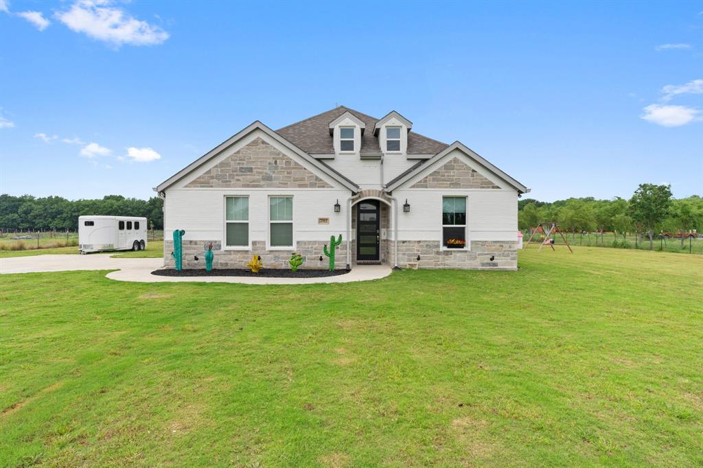 a front view of a house with a garden and yard