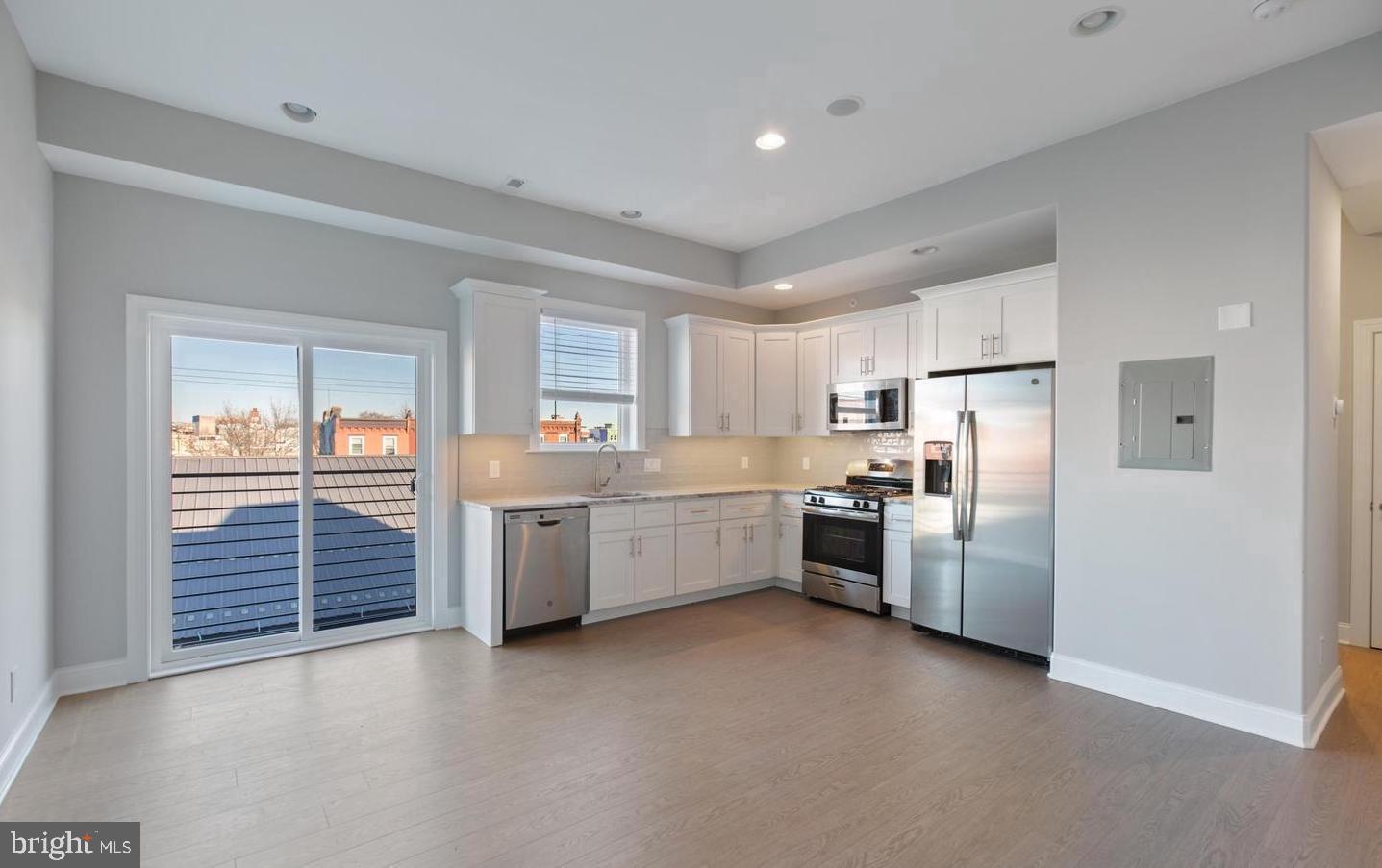 a kitchen with granite countertop a refrigerator and a sink