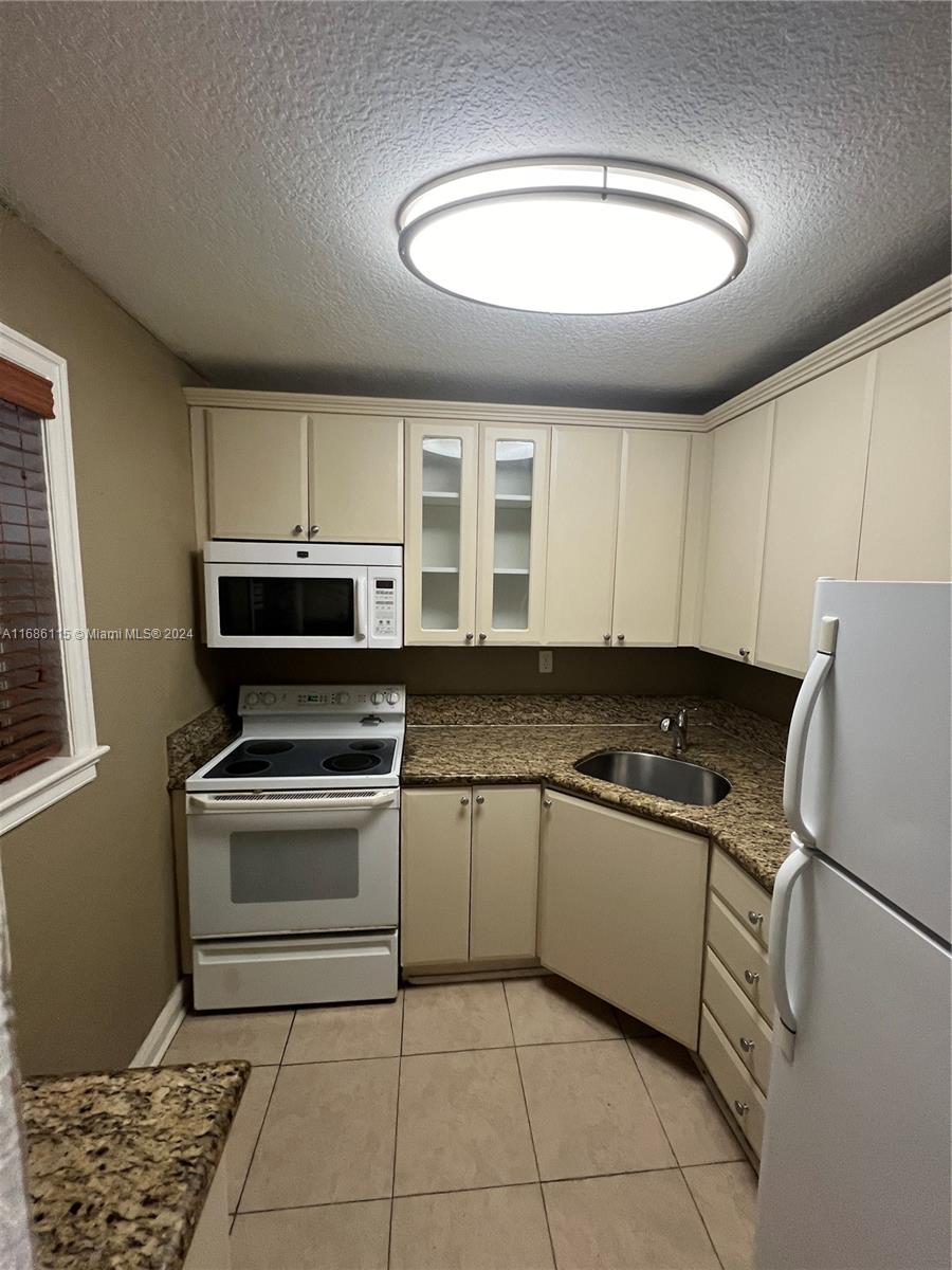 a kitchen with a stove a sink and a refrigerator