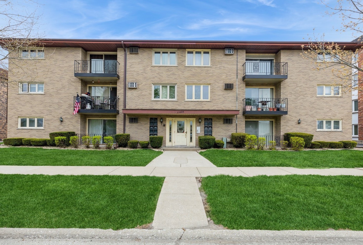 a front view of a residential apartment building with a yard