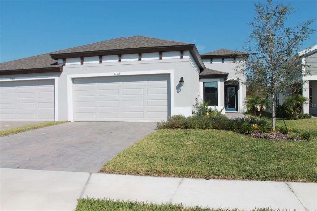 a front view of a house with a yard and garage