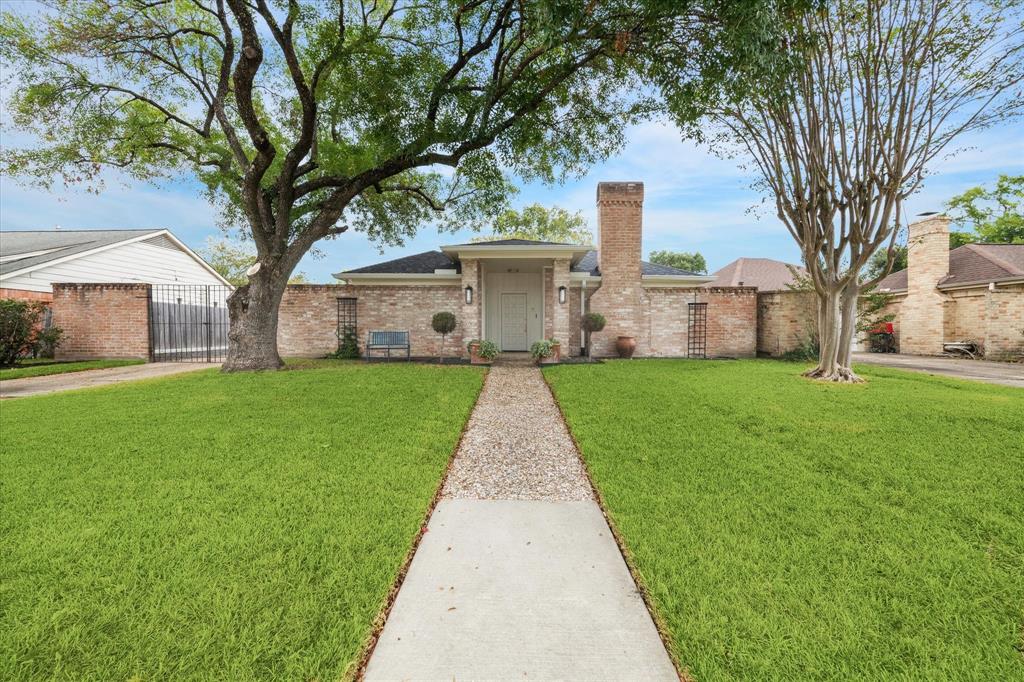 a front view of a house with a yard and trees