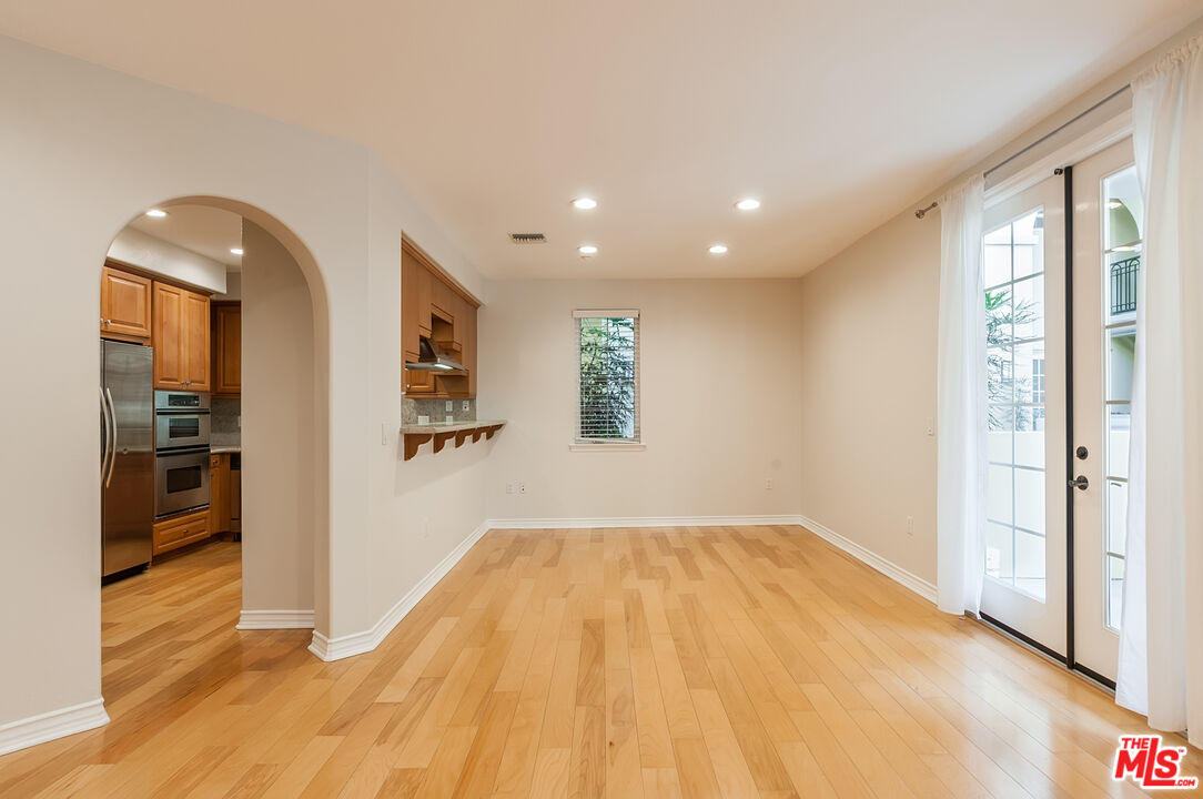 a view of empty room with wooden floor and windows