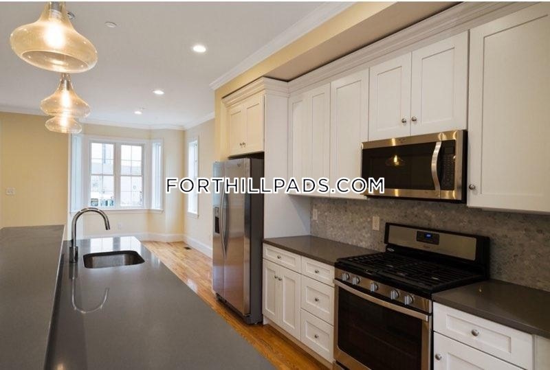 a kitchen with stainless steel appliances a stove a sink a microwave and cabinets