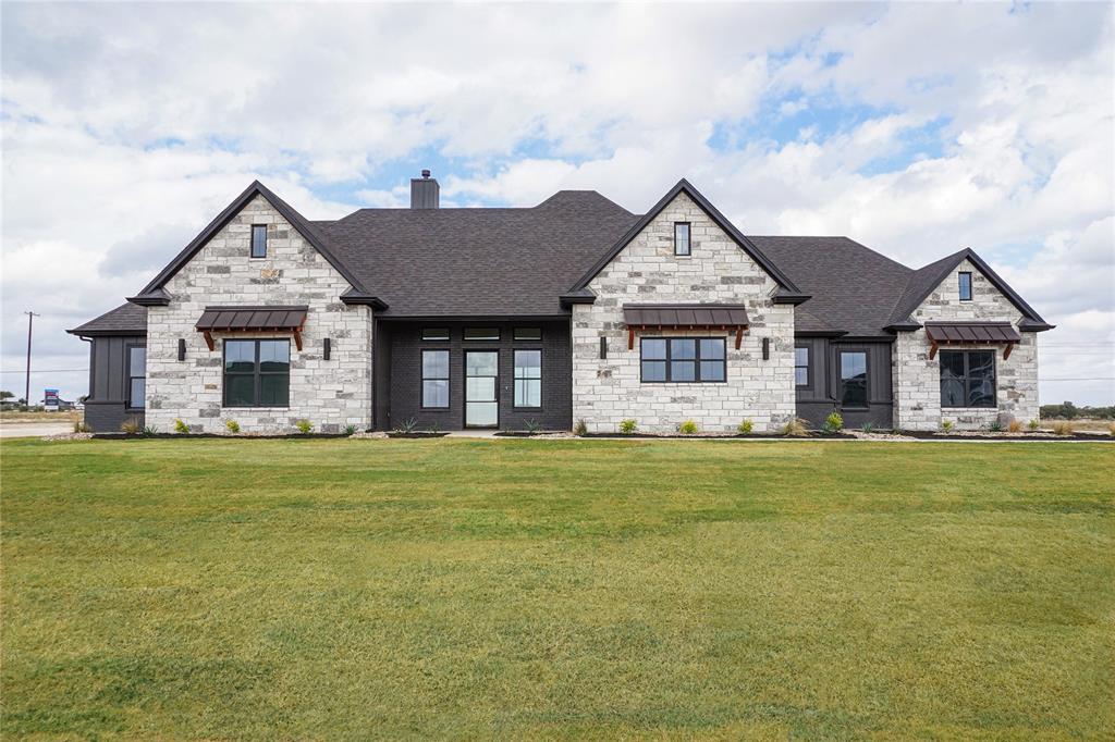 a view of a big house with a big yard and large trees