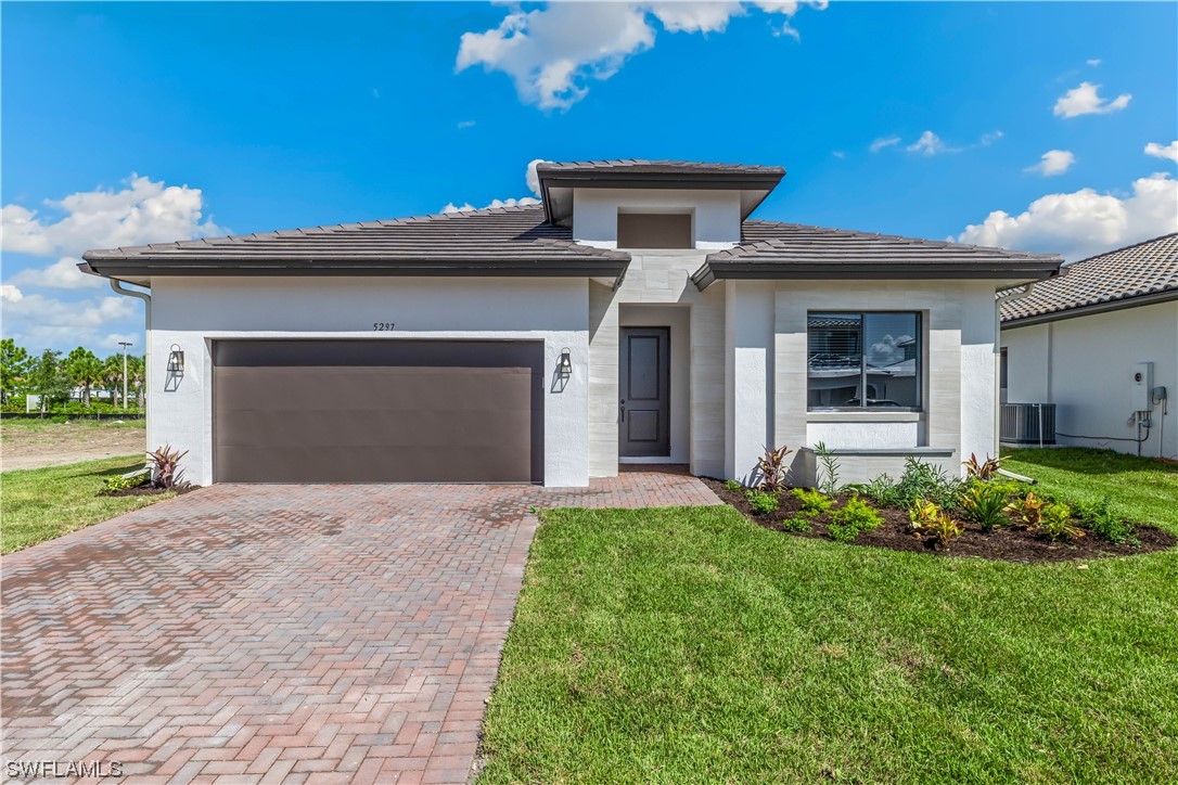 a front view of a house with a yard and garage