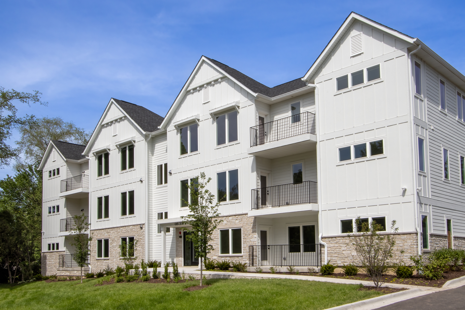 a front view of a residential apartment building with a yard