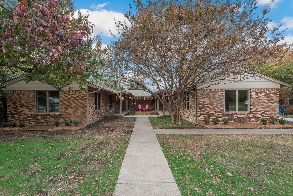 a front view of a house with a yard and trees