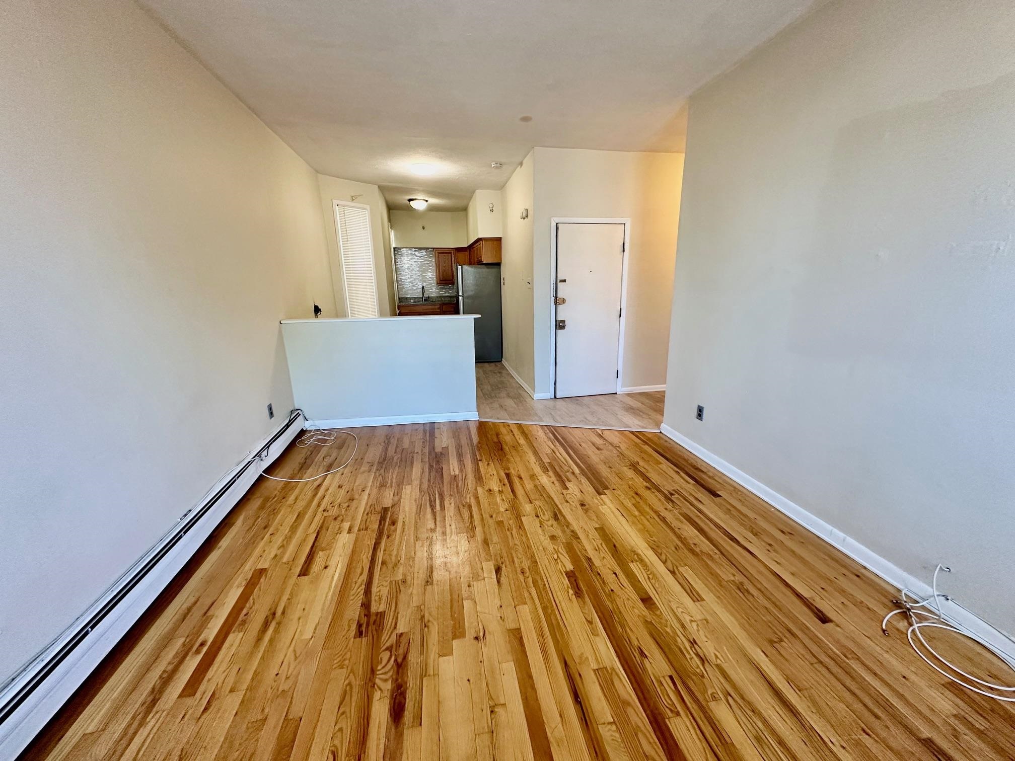 a view of a room with wooden floor