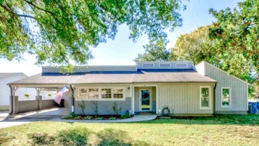 View of front of house featuring a front yard and a carport