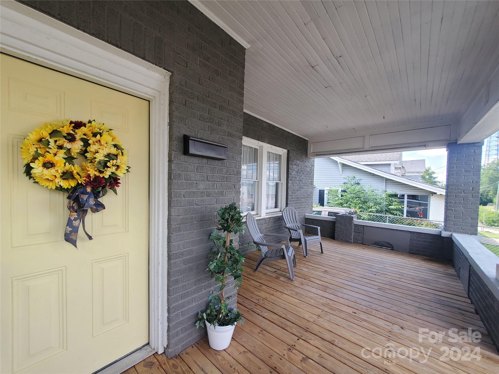 a view of a porch with chairs and potted plants