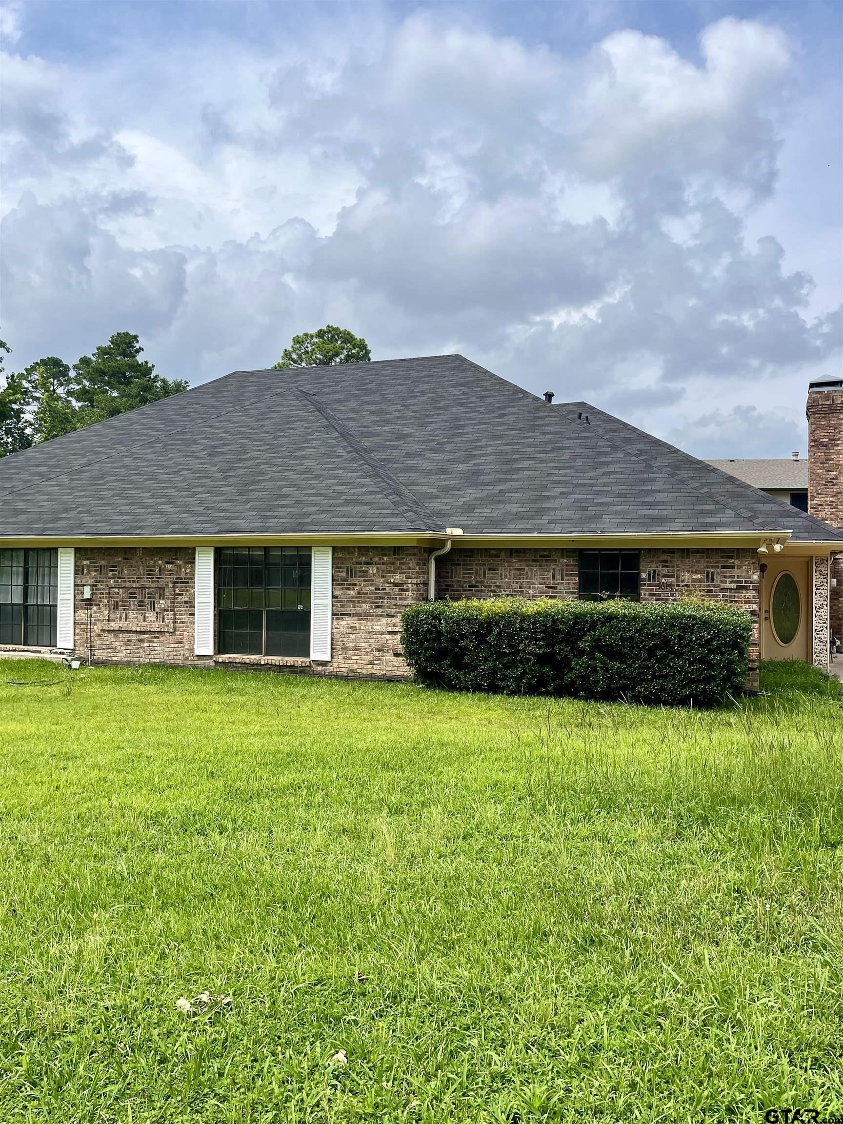 a front view of house with yard barbeque and outdoor seating