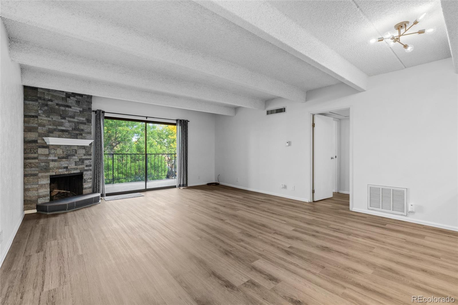 wooden floor fireplace and windows in an empty room