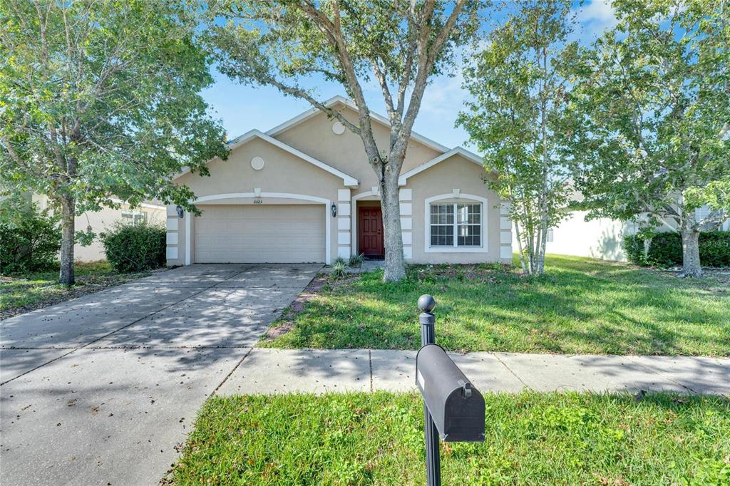 front view of a house with a yard and an trees