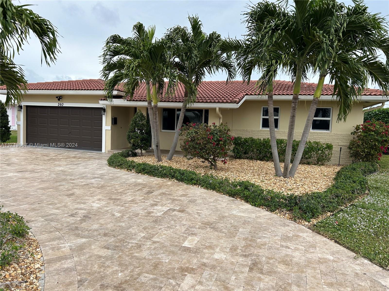 a front view of a house with a garden