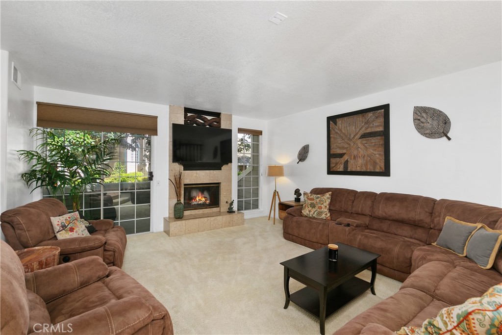 a living room with furniture a fireplace and a flat screen tv