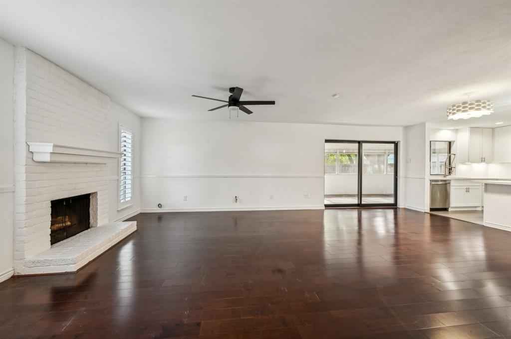 a view of empty room with wooden floor and fireplace