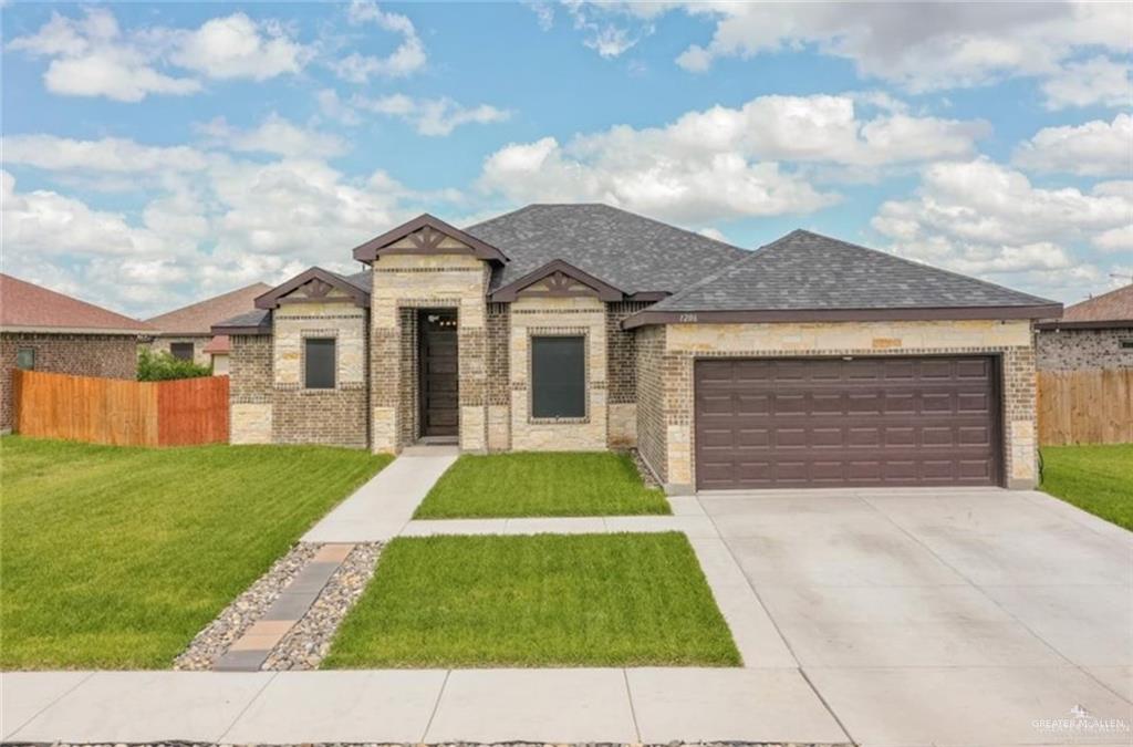 View of front of home featuring a front yard and a garage