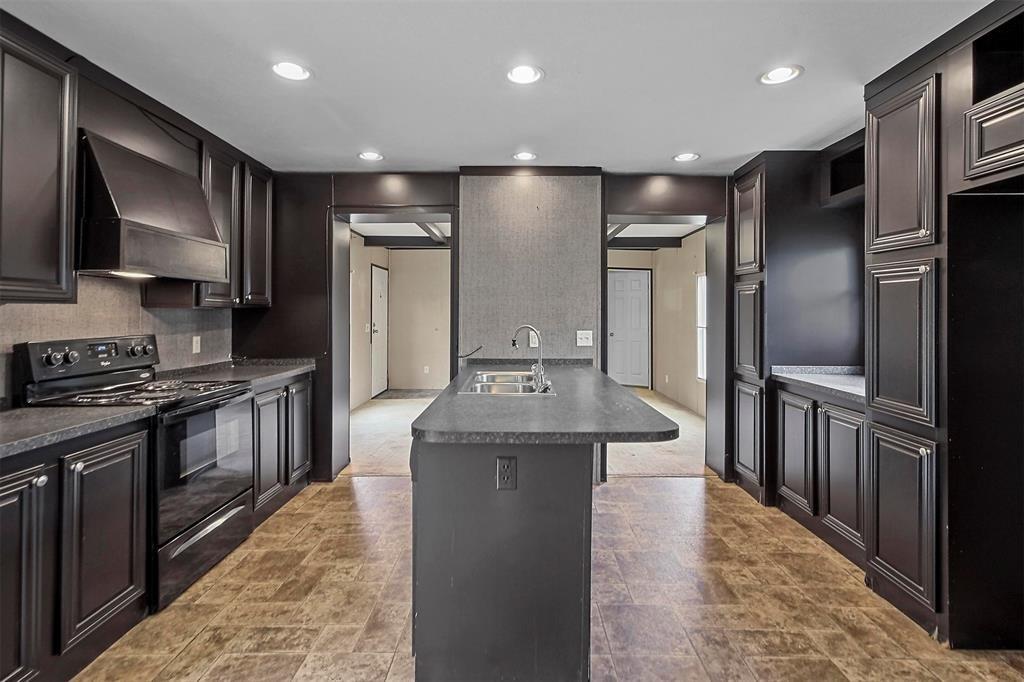 a kitchen with stainless steel appliances granite countertop a stove a refrigerator and a sink