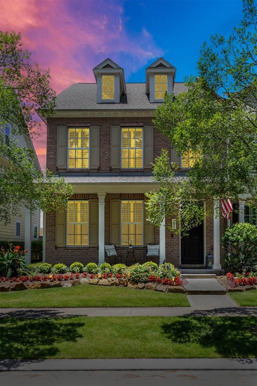 a front view of a house with a yard and potted plants