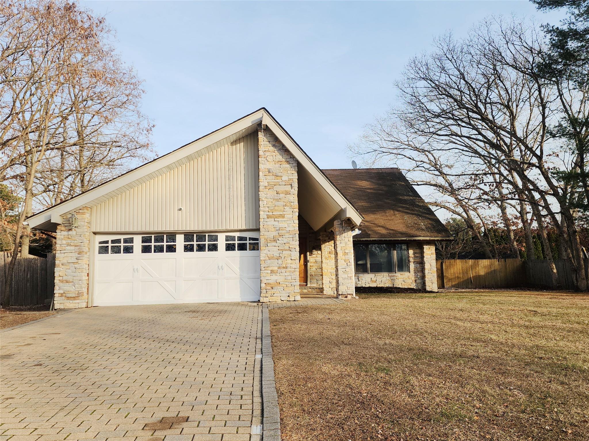 View of front of house featuring a garage and a front lawn