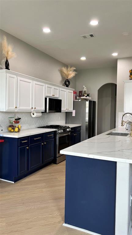 a large kitchen with kitchen island a sink stainless steel appliances and cabinets