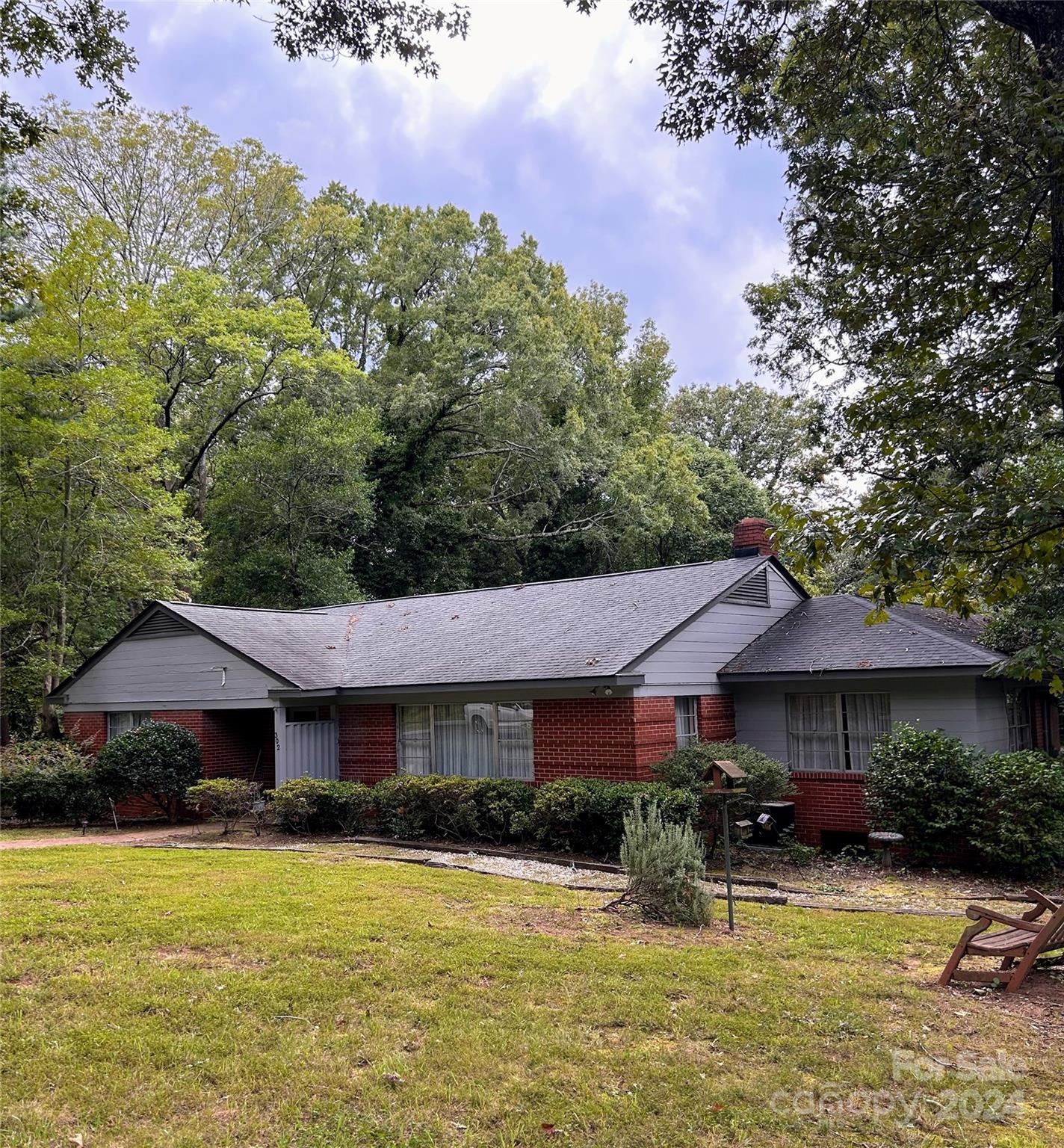 a front view of a house with yard and mountain view