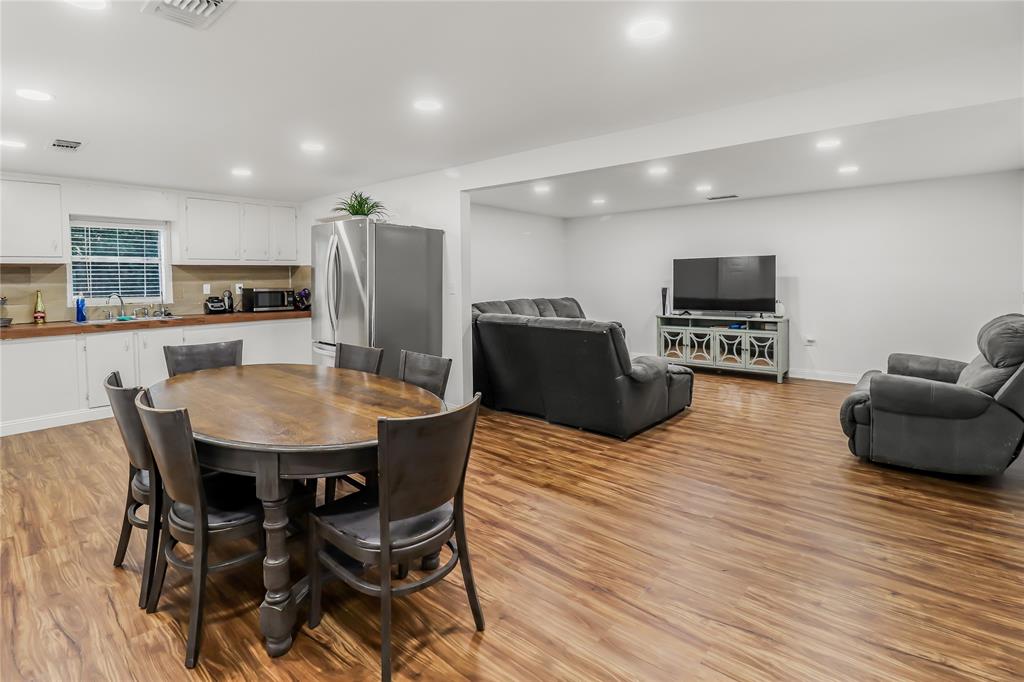 a living room with furniture a flat screen tv and kitchen view