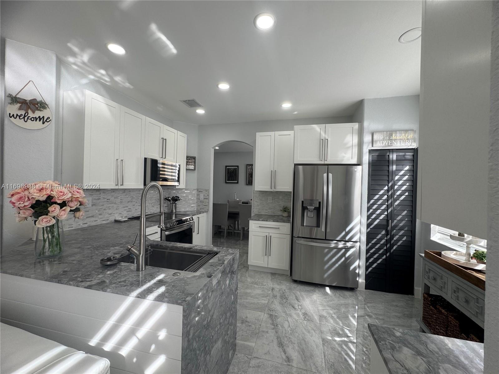 a kitchen with refrigerator and microwave