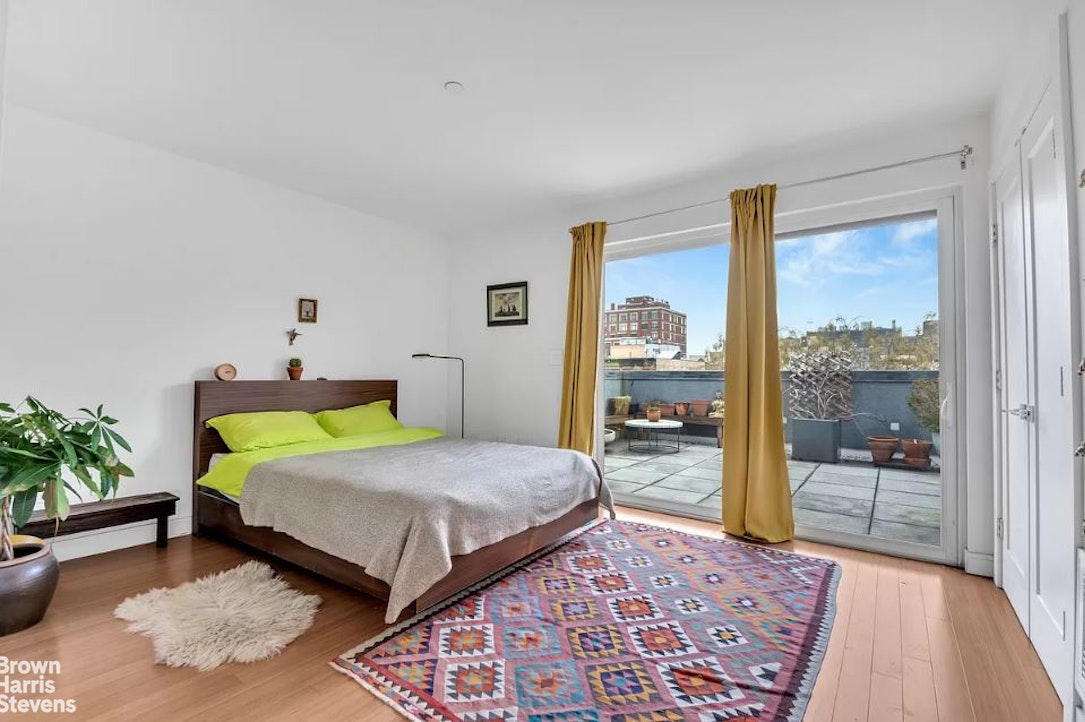 a bedroom with a bed lamp and a large window