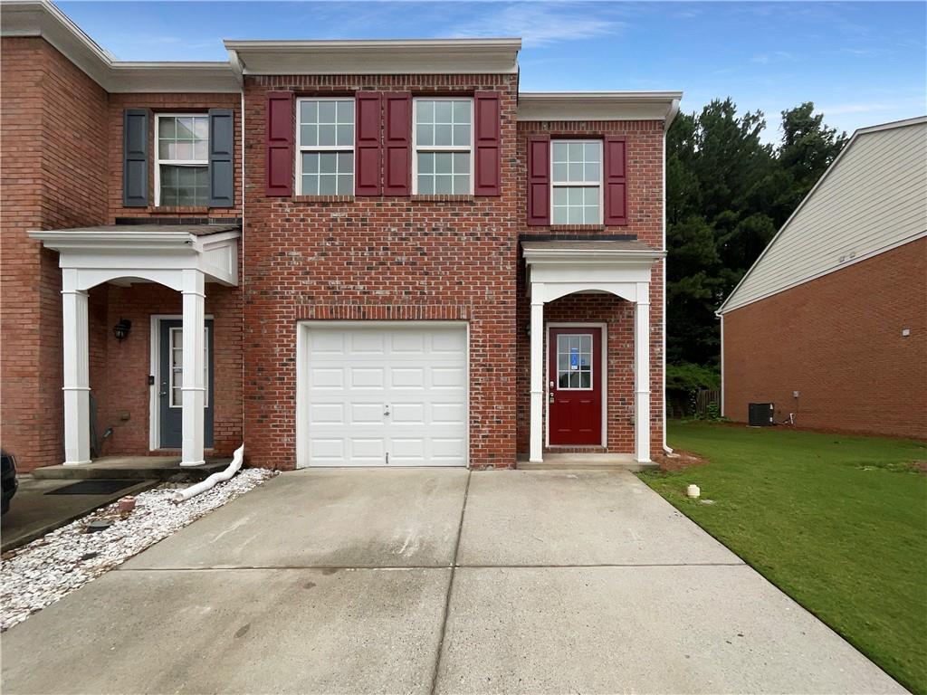 a front view of a house with yard and garage