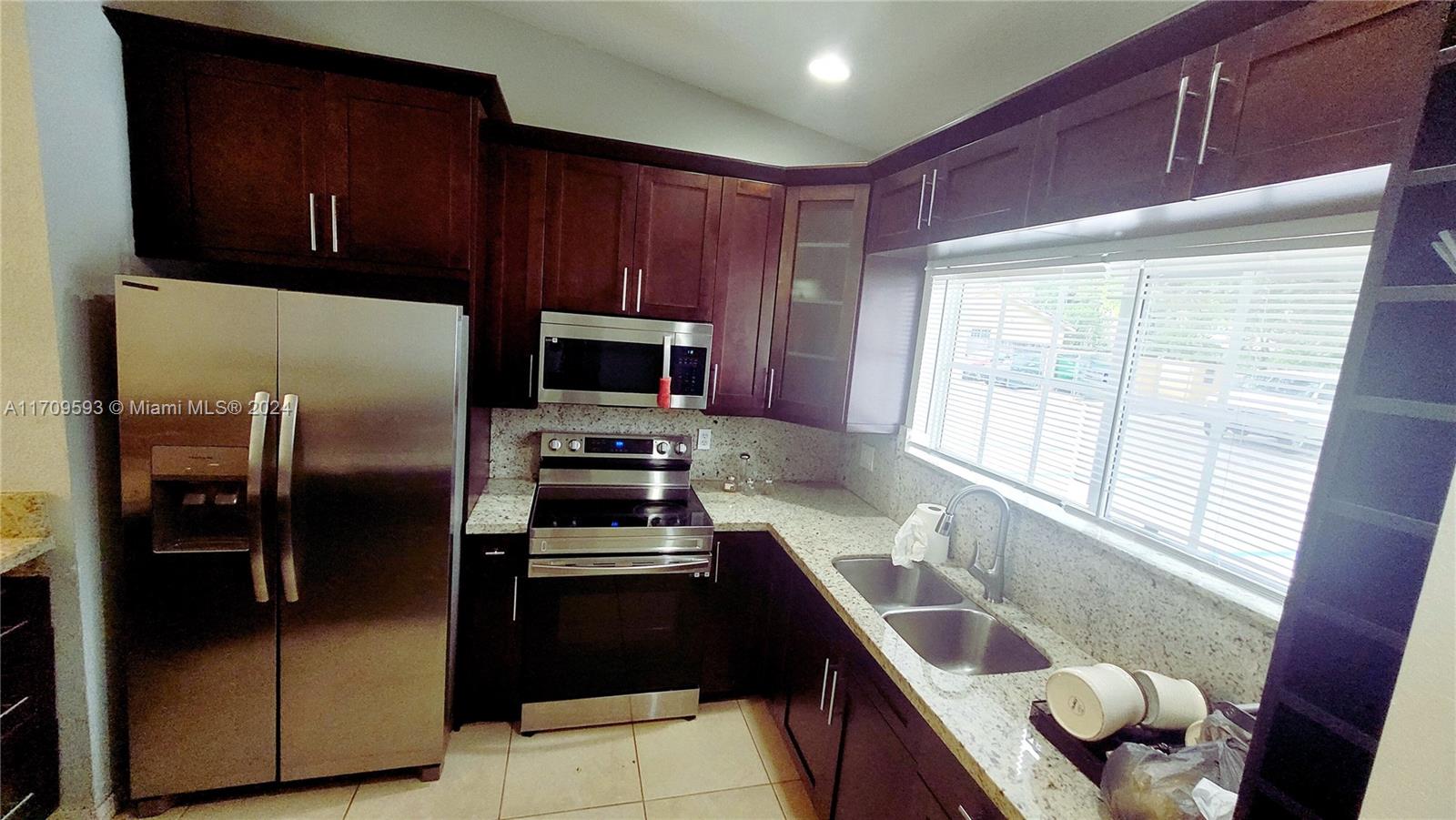 a kitchen with stainless steel appliances granite countertop a refrigerator and a sink