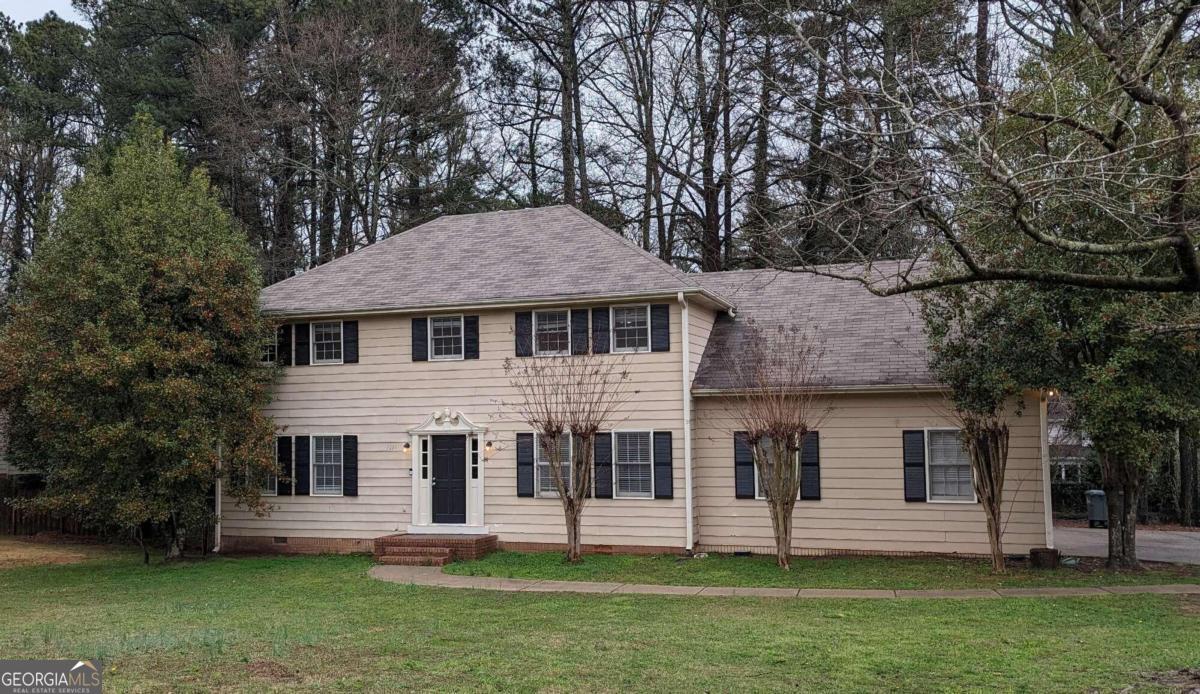 a front view of a house with a garden and yard