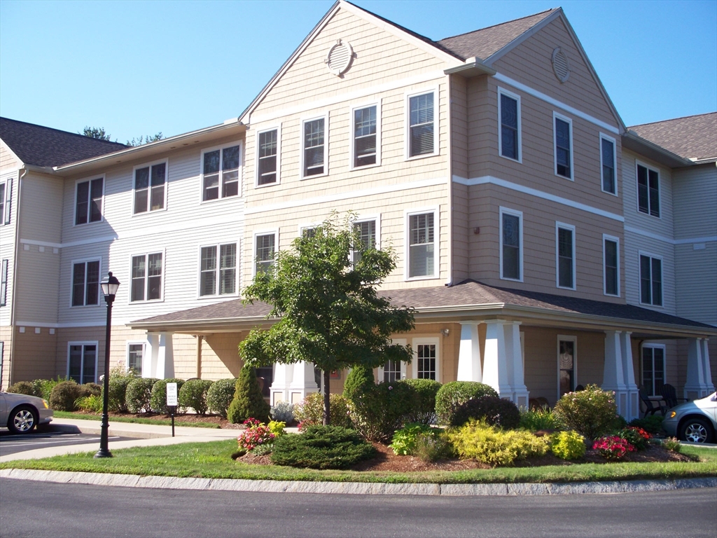 a front view of a residential apartment building with a yard