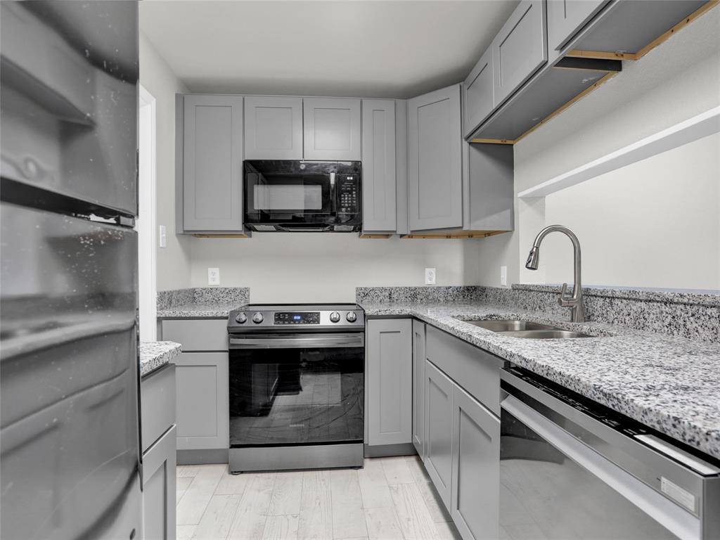 a kitchen with stainless steel appliances granite countertop a sink stove and cabinets