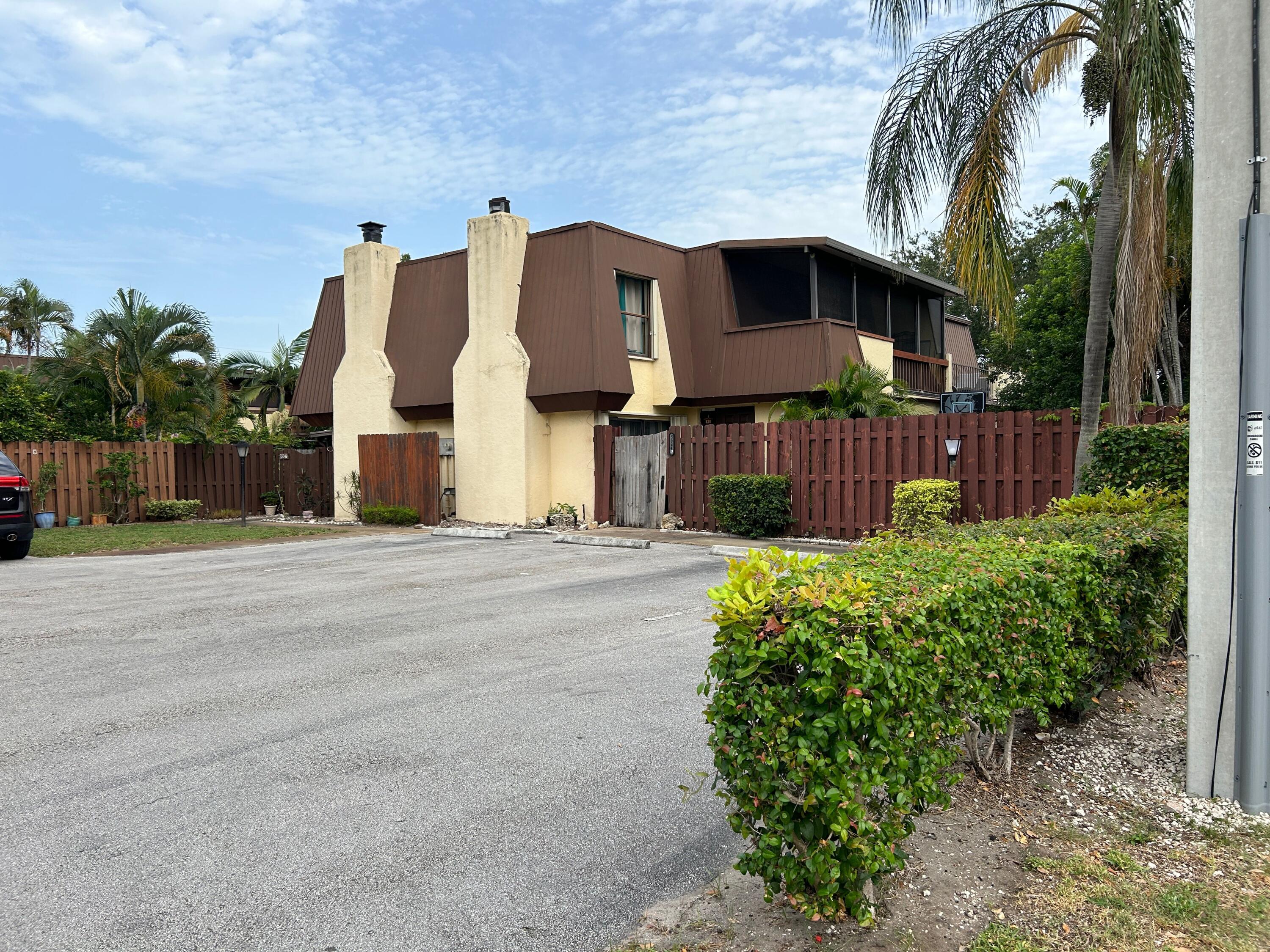 a view of a house with a small yard and a large tree