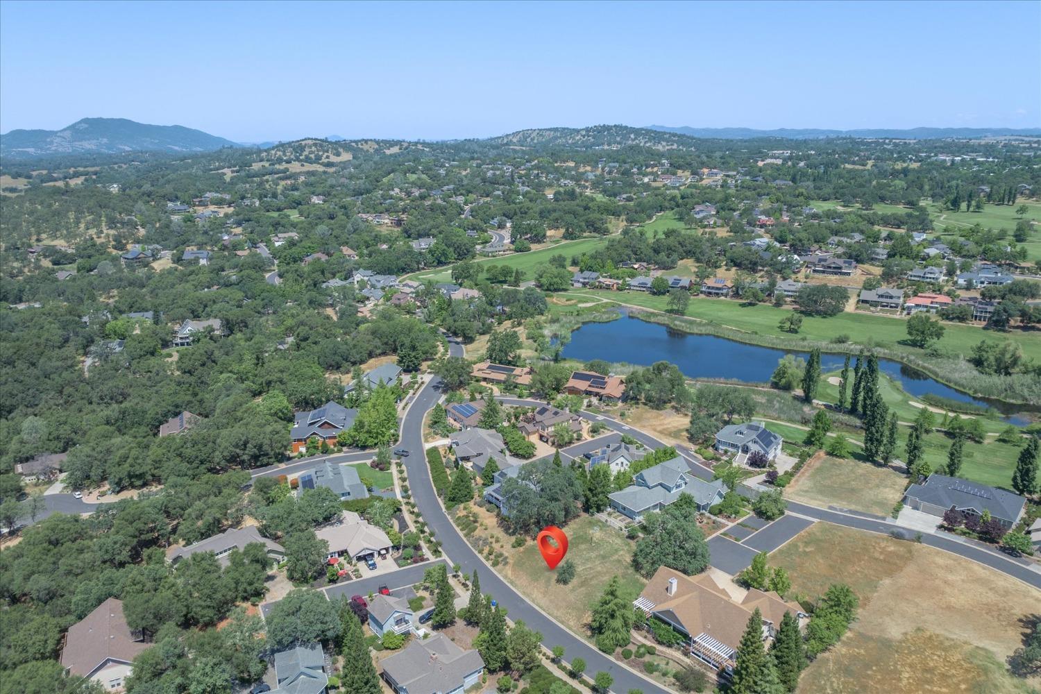 an aerial view of residential houses with outdoor space and trees