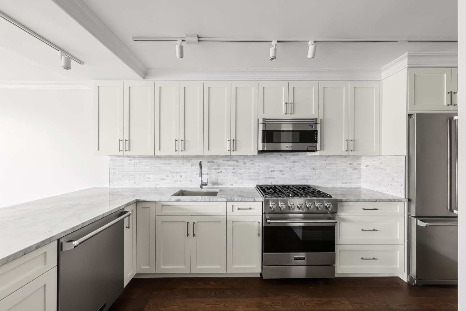 a kitchen with white cabinets and stainless steel appliances