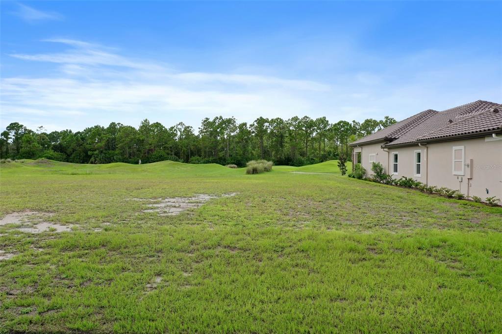 a view of a green field with wooden fence