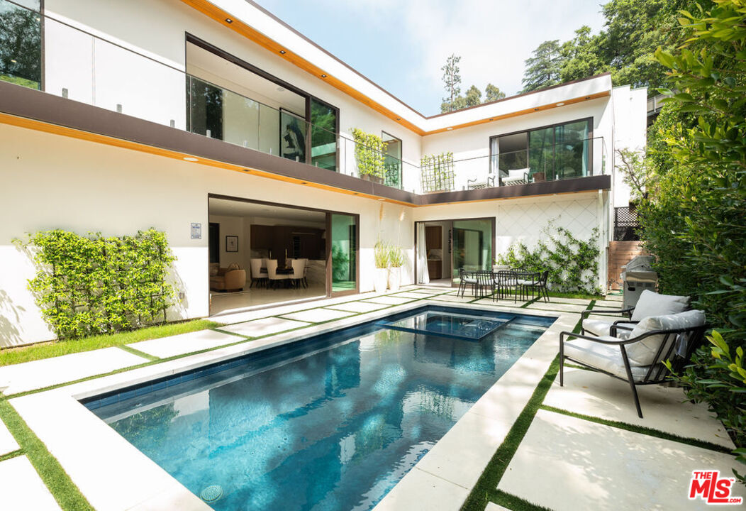 a view of a house with swimming pool and sitting area