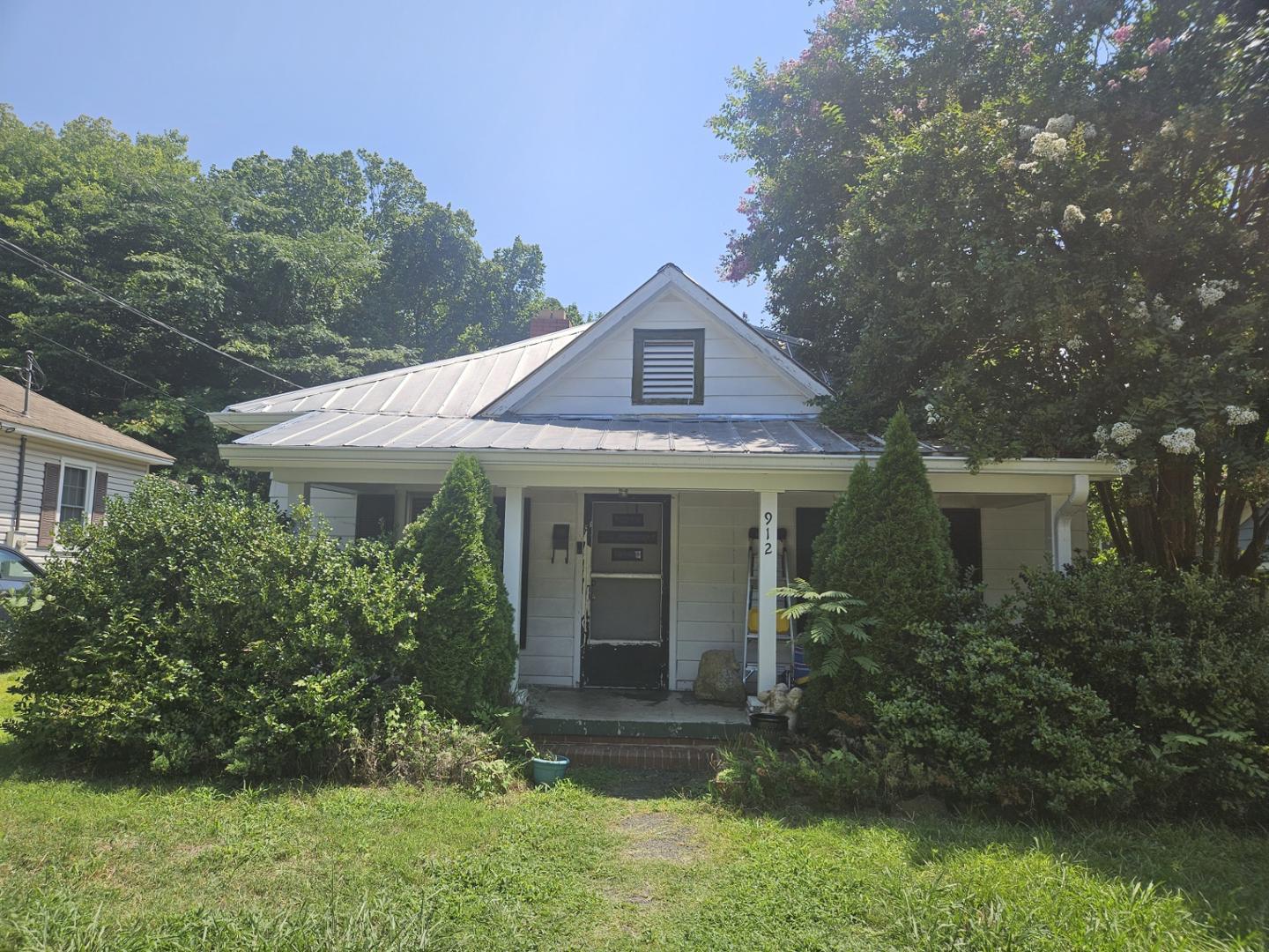 a front view of a house with a yard and trees