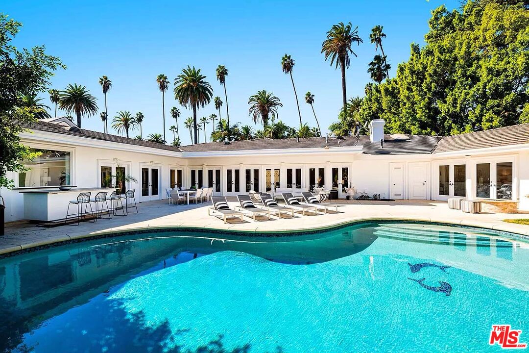 a view of a house with swimming pool and sitting area