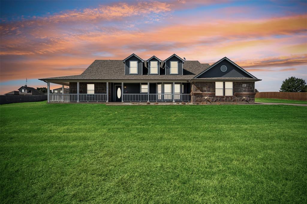 a view of a house with a big yard and large trees